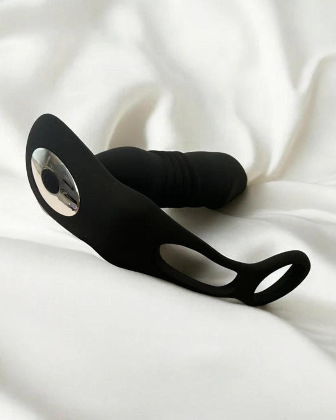 a prostate massager laying on top of a white sheet