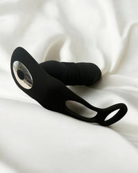 a prostate massager laying on top of a white sheet