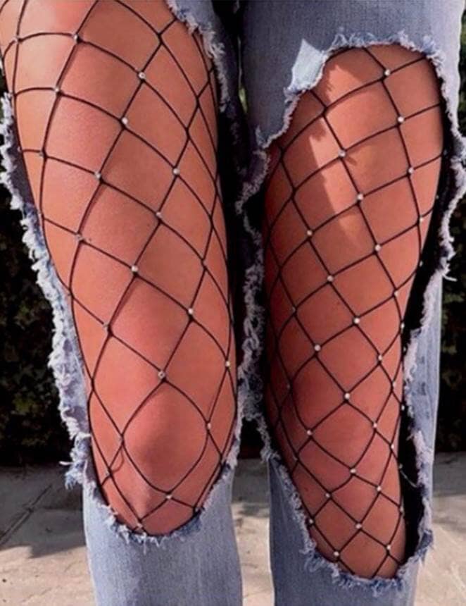 the legs of a woman wearing ripped jeans