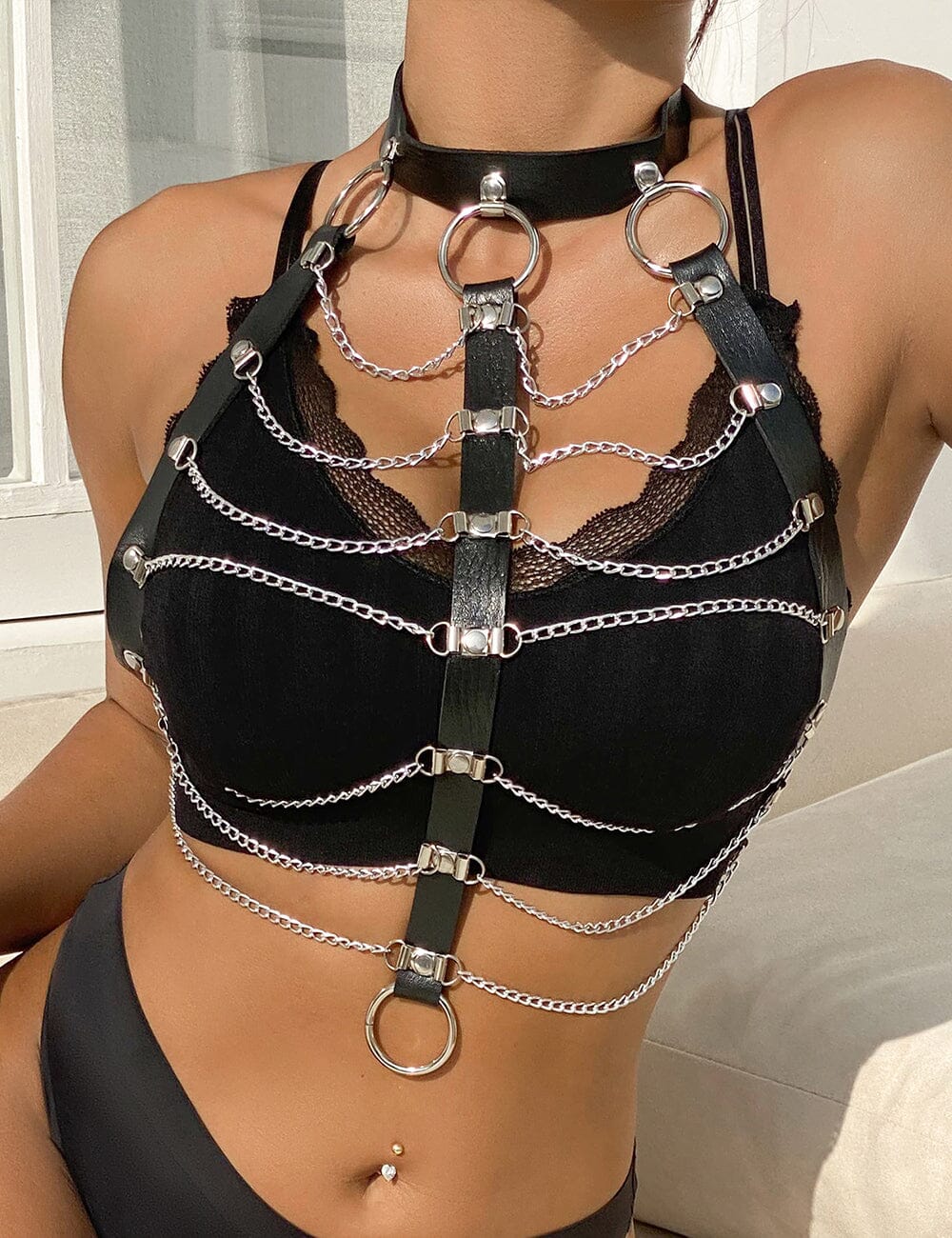 a woman wearing a black bra with chains on it