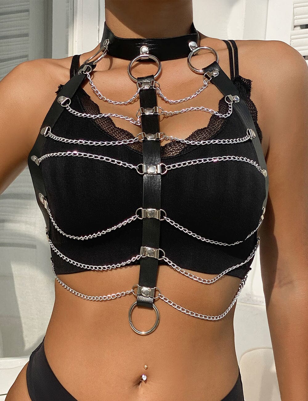 a woman wearing a black top with chains on it