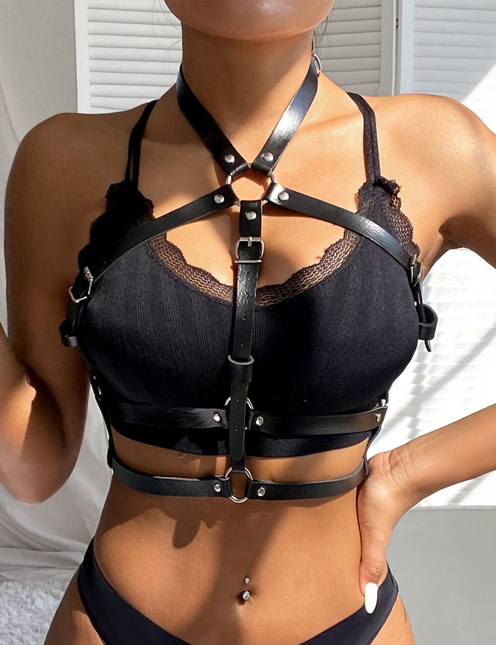 a woman wearing a black bra and harness