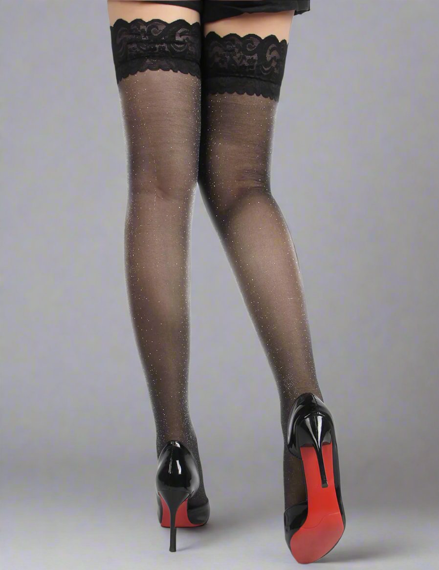 a woman on a grey studio background wearing black glitter hold up stockings by scandals and high heels