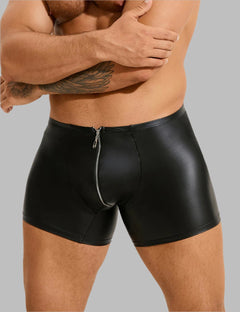 a man in black leather shorts with his arms crossed