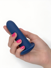 Close-up of a sleek anal probe from the They-ology 5-Piece Wearable Anal Training Set, held delicately to illustrate its ergonomic design and luxurious silicone finish.