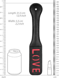 Image illustrating the dimensions of a chic paddle adorned with 'LOVE', positioned next to everyday items for scale, enhancing its luxurious aesthetic.