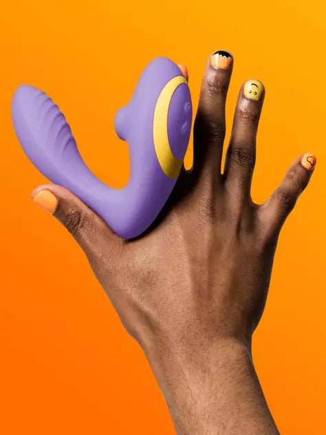 a hand holding a purple and yellow object