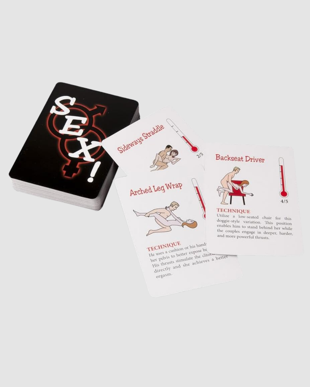 A couple playing "A Year Of Sex" sexual positions card game with dice set, featuring colorful game cards on a table.