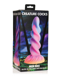a pink, blue, and purple swirling unicorn horn dildo by creature cocks inside the box