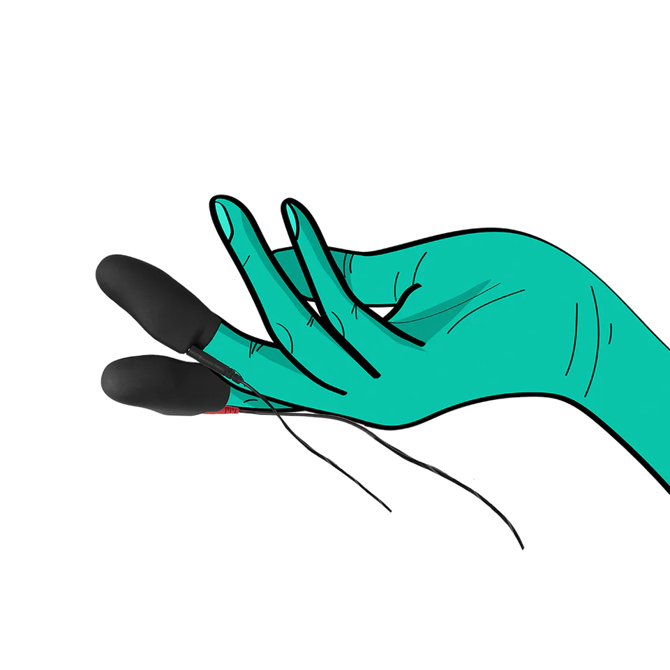 a hand with a green glove holding a black object