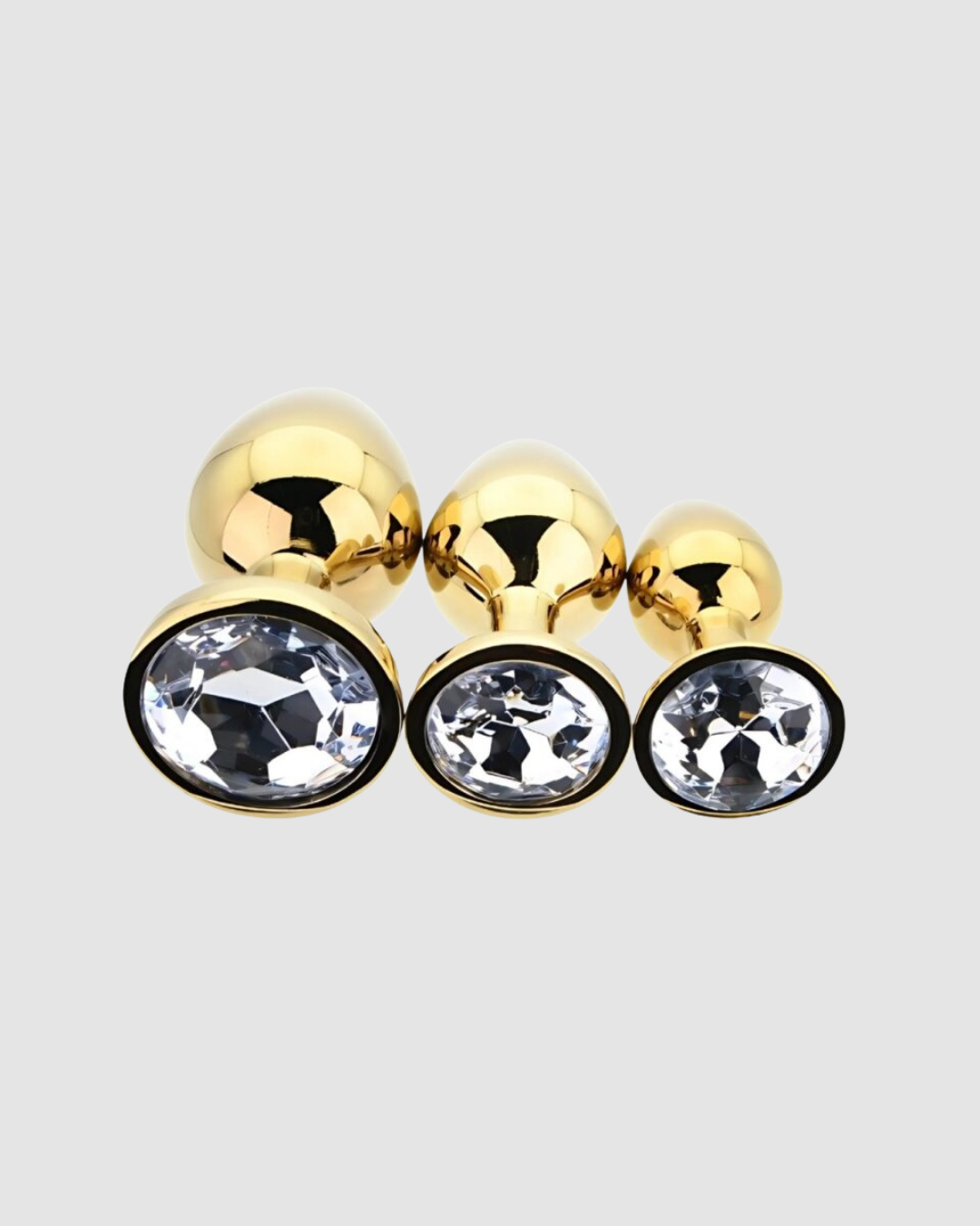 Toosh metal anal kit featuring three butt plugs with clear stones in varied sizes for versatile pleasure and smooth, durable design.