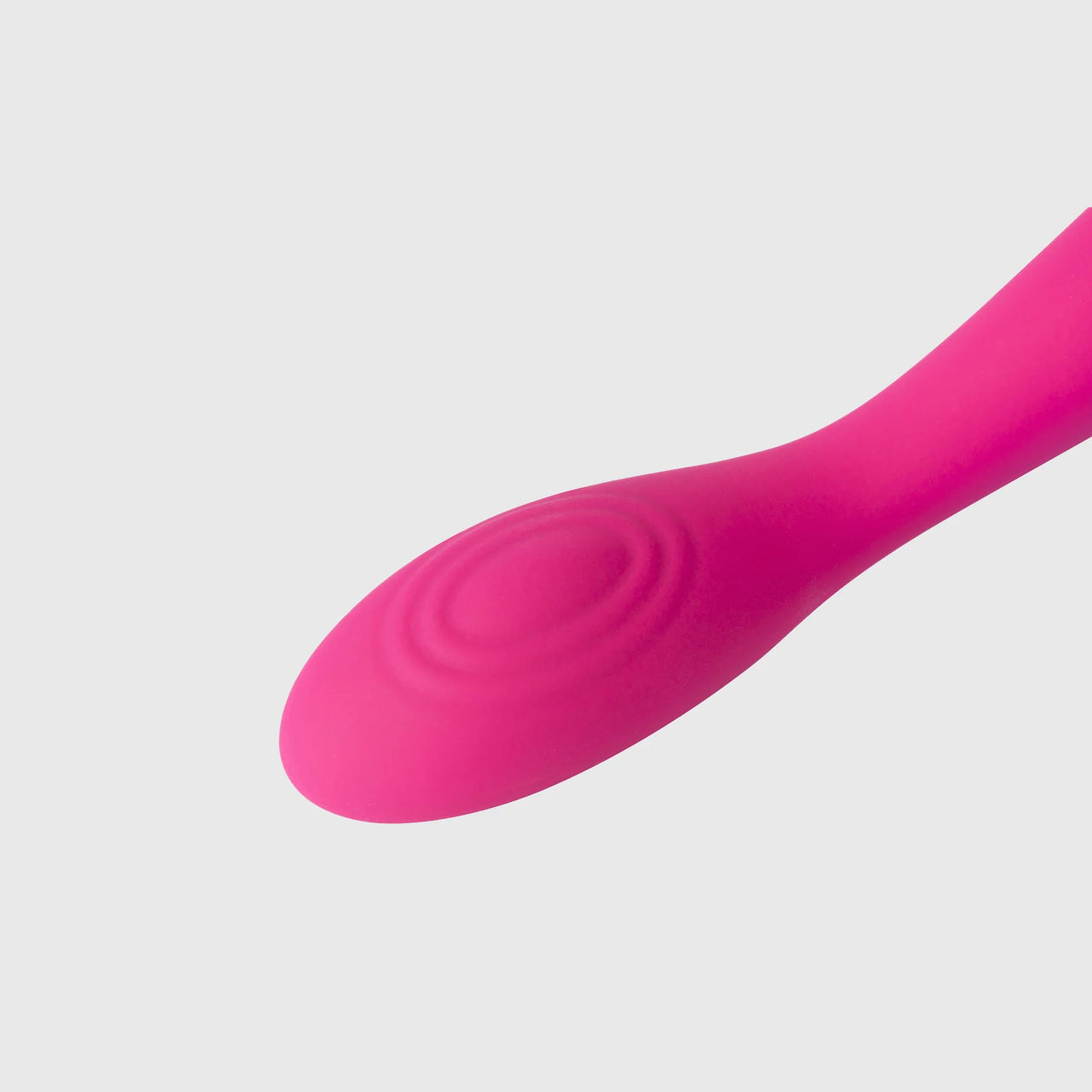 a close up of the tip of a pink vibrator on a white background