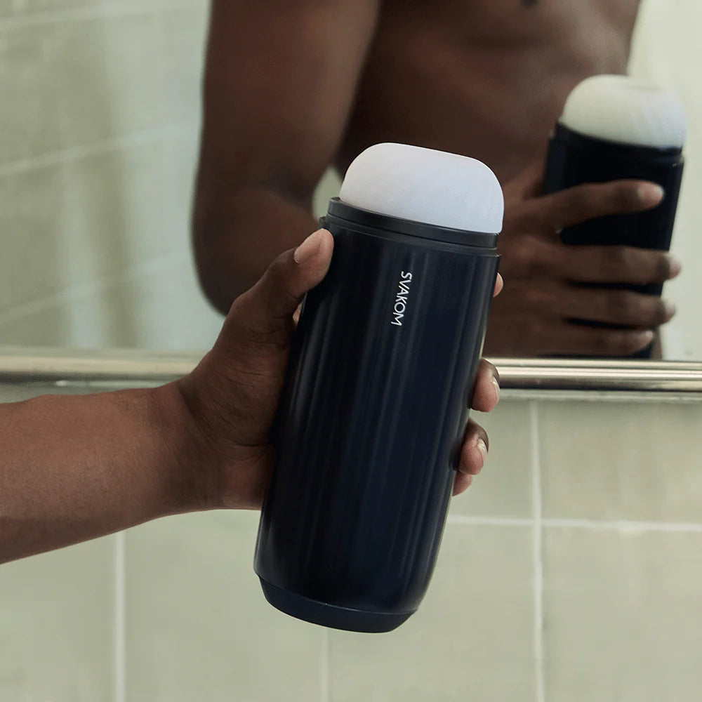 a person holding a cup in front of a mirror