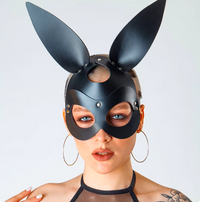 a woman wearing a black bunny mask with ears