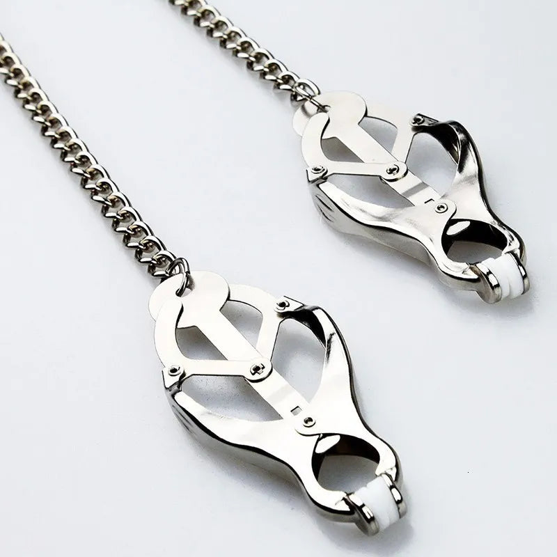 Scandals Adult Store nipple clamps with chain for sensory play, featuring adjustable metal clamps on the nipples for adult BDSM pleasure.