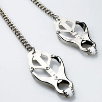 Luxurious metal clover nipple clamps with a shining silver chain, designed for sensory play and erotic enjoyment.