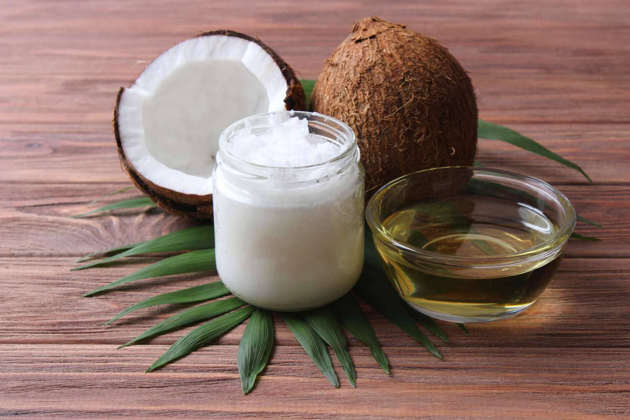 a bottle of coconut oil next to a glass of coconut oil
