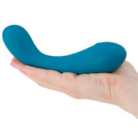 a person holding The Swan Curve - Squeeze Control G-Spot Vibrator in Teal flat in their palm