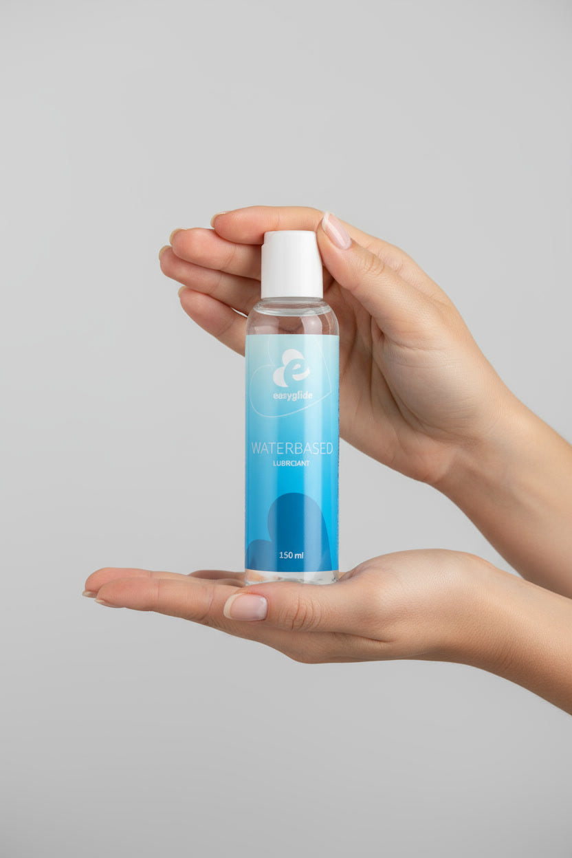 EasyGlide Waterbased Lubricant 150ml held in woman's hands against a light grey background, showcasing the product's packaging.
