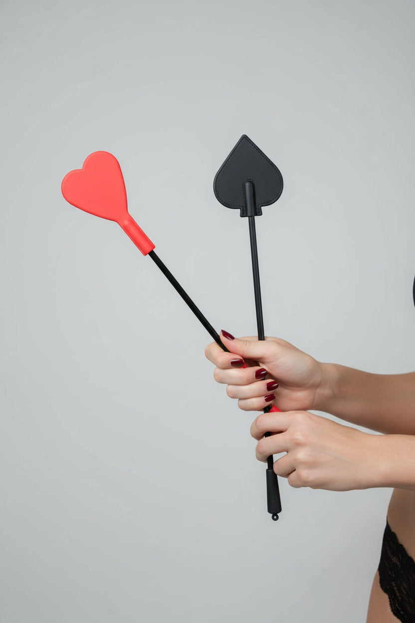 Fetish Fantasy silicone heart crop flapper with red and black design, held by woman's hands, for fetish exploration.