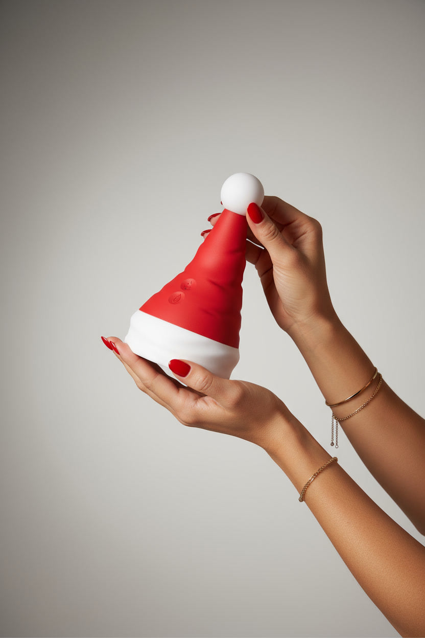 Scandals Christmas sex toy with a magical Santa hat, featuring a rolling clitoral massager and G-spot vibrator in a woman's hands.