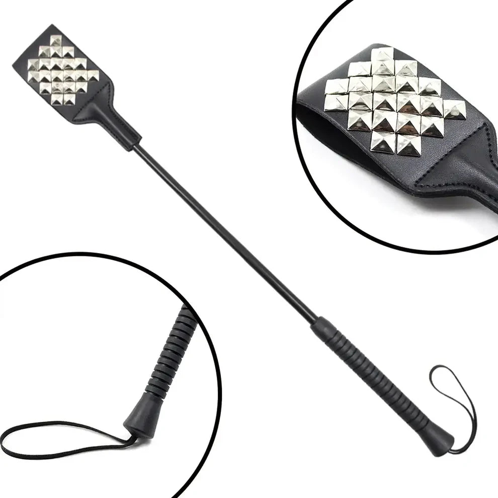 Luxurious spiked riding crop in action, featuring a long faux leather shaft, a rubber golf club style handle, and detailed metal spikes, perfect for immersive play.