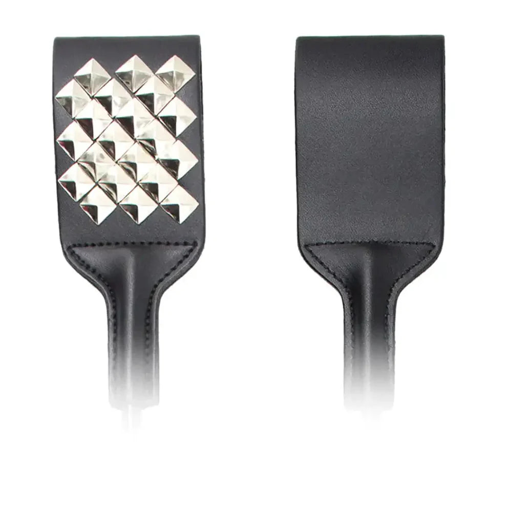 Close-up view of a spiked riding crop's handle and tip, displaying intricate metal spikes on the faux leather surface, highlighting its unique craftsmanship.