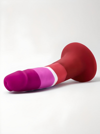 Avant Lesbian Pride Silicone Suction Dildo lying down, highlighting its beautiful design and soft silicone material, perfect for hands-free pleasure.