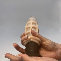 Thumbnail for a woman's manicured hand hand holding a dildo with masturbator on top
