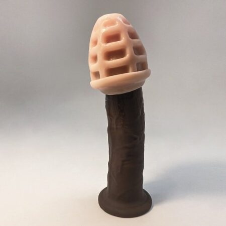 an upright dildo with masturbator toy placed on top