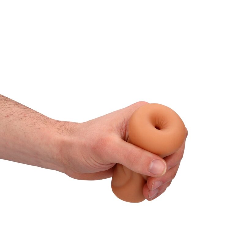 a hand holding a fake doughnut on a white background