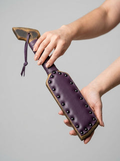 Barrel of Pain padded paddle for impact play, featuring a sturdy handle and padded surface for comfortable use during BDSM activities.