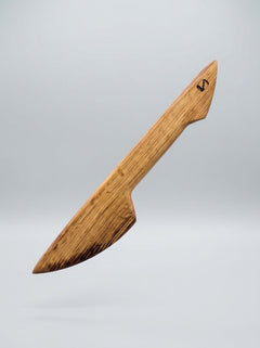 Handcrafted wooden BDSM wax play scraper made from whisky barrel oak, featuring double-ended design for kink and sensory stimulation.