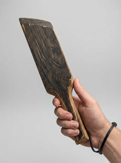 Mini Paddle from Barrel of Pain, a black leather flogger suitable for BDSM play, with a compact, textured paddle head.