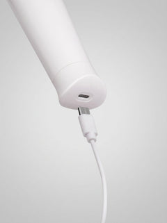 Le Wand Classique Petite Vibrating Wand Massager White presented elegantly, emphasizing its ergonomic design and 10 deep, rumbly vibration speeds.