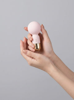 Pokewan Pocket Mini Vibrating Wand Massager held in one hand, showcasing its compact mini wand design in pale pink