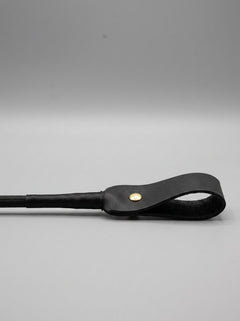 Bound Noir nubuck leather BDSM riding crop with a sleek handle and slender shaft, designed for impact play and control.