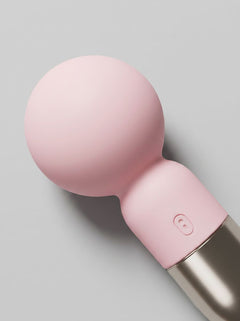 Close-up of the pale pink Pokewan Pocket Mini Vibrating Wand Massager with rounded head, flexible neck and gold-tone handle