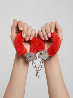 Loving Joy Furry Handcuffs on a satin backdrop, emphasizing the sophistication and luxury of these adjustable cuffs for sensual play.