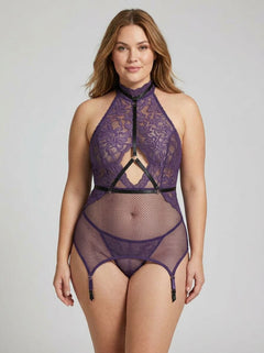 Model showcasing the Dreamgirl 3pc Aubergine Lace & Fishnet Garter Slip Chemise, Harness and Thong Set. The stunning chemise set features sheer lace and fishnet, highlighting a curvaceous silhouette with luxurious details.