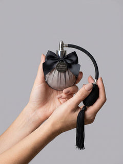 Elegant display of L'essence du Boudoir perfume, a sensual fragrance inspired by ancient Kamasutra, perfect for linens.