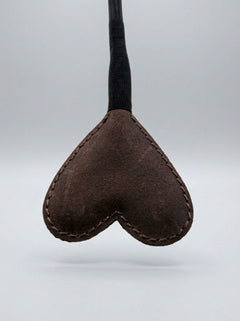 Artistic shot of the Bound Nubuck Leather Heart Crop in action, perfectly illustrating the blend of pleasure and pain in luxury play.