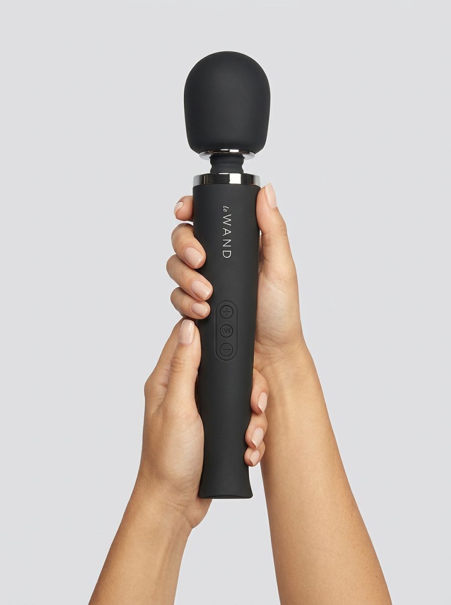 Le Wand Rechargeable Wand Massager Vibrator Black held upright in both hands, showcasing its premium black finish and rounded silicone head.