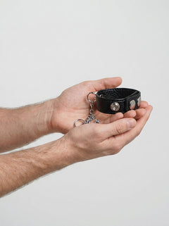 Side view of the Blue Line Snap Cock Ring With Leash, highlighting the sturdy metal loop and leash, ideal for BDSM play.