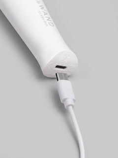 The compact Le Wand Classique Mini Vibrating Wand Massager positioned in a stylish handbag, exemplifying its discreet and portable nature.