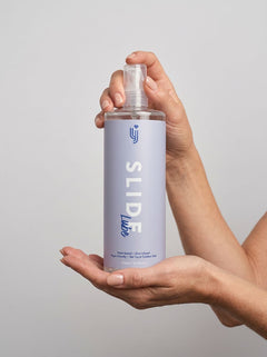 Loving Joy Slide Water-Based Lubricant displayed elegantly among soft materials, representing a blend of comfort and pleasure.