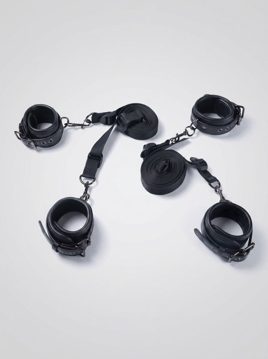 Luxury Faux Leather Bondage Bed Restraint Kit displayed with four black cuffs, adjustable straps and connectors for bed restraint play