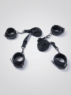 Luxury Faux Leather Bondage Bed Restraint Kit displayed with four black cuffs, adjustable straps and connectors for bed restraint play