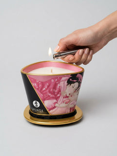 Shunga Sensual Soy Wax Erotic Massage Oil Candle 170ml massage candle being lit with a lighter on its gold base