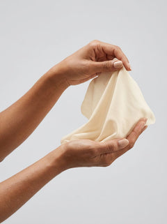 Hands gently stretching a Sheer Glyde Vegan Dams Vanilla Flavour 4 Pack latex sheet for comfortable oral dams use